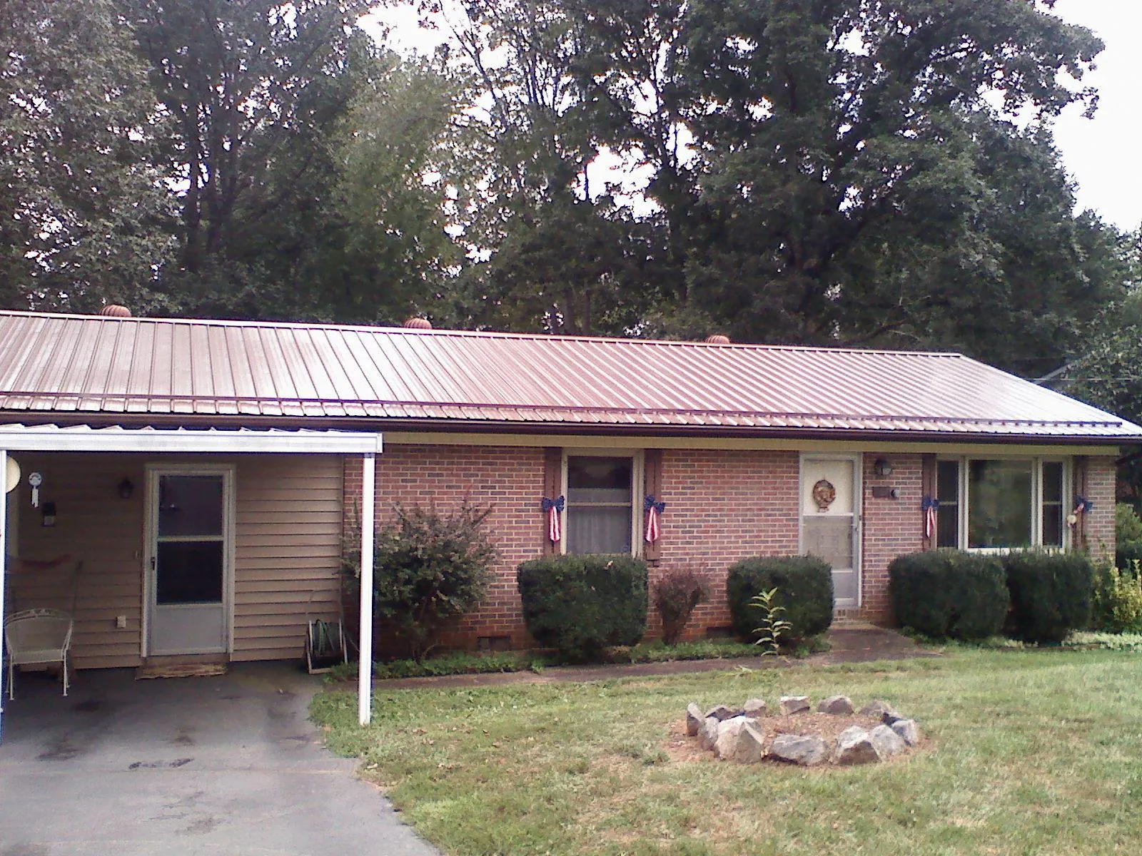 Bronze metal roof and carport on a brick ranch home — Roof Repair work by our crew in Glen Oaks